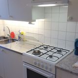 Kitchen and stove in 1-bedroom corporate apartment.