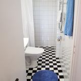 Fully tiled Wc and shower in 1-bedroom corporate apartment.