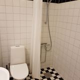 Helkaklad WC och dusch i företagslägenhet på bottenplan.